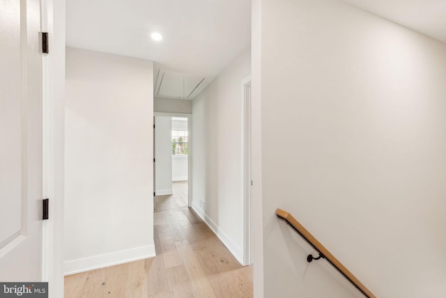 hall with an upstairs landing, attic access, light wood-style flooring, baseboards, and recessed lighting