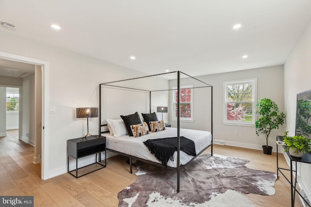 bedroom featuring light wood finished floors, recessed lighting, and multiple windows