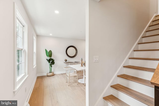 stairs with recessed lighting, wood finished floors, and baseboards