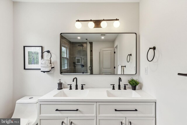 full bathroom with toilet, a sink, double vanity, and a stall shower