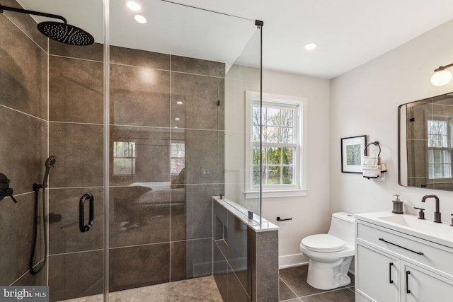 full bathroom featuring tile patterned floors, toilet, vanity, baseboards, and tiled shower