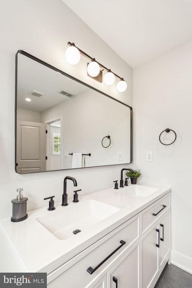 bathroom featuring double vanity, visible vents, and a sink
