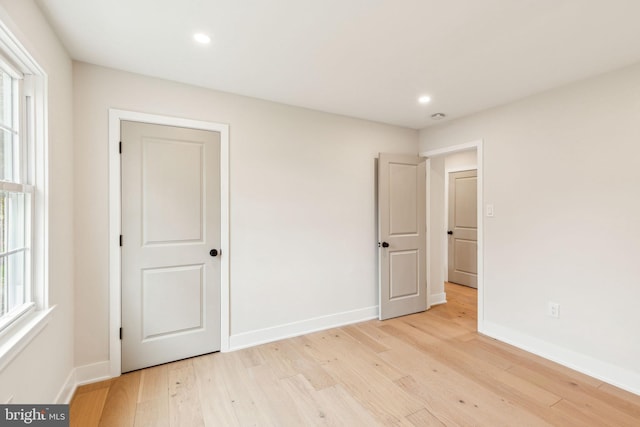 unfurnished bedroom with light wood-type flooring, baseboards, and recessed lighting