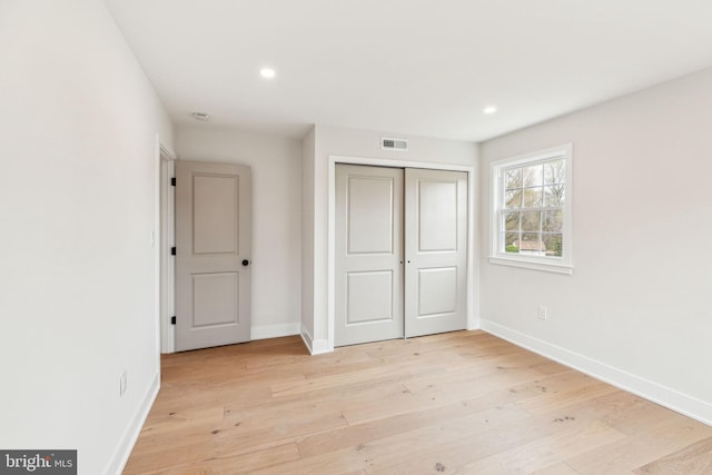 unfurnished bedroom with baseboards and light wood-type flooring