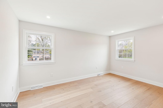 empty room featuring baseboards, light wood finished floors, visible vents, and recessed lighting