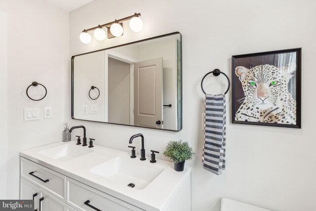 bathroom featuring a sink, double vanity, and toilet
