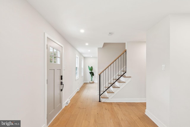entryway featuring recessed lighting, light wood-style floors, baseboards, and stairs