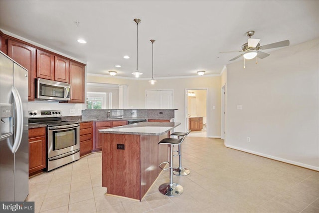823 Oyster Bay Pl Unit 302, Solomons, MD 20688 - kitchen featuring appliances with stainless steel finishes, a breakfast bar, a center island, ceiling fan, and a sink