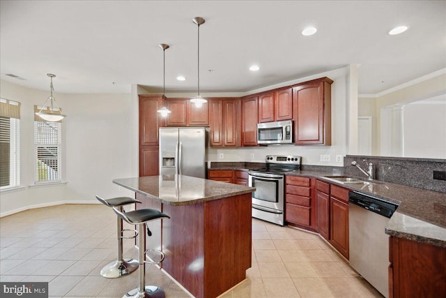 823 Oyster Bay Pl Unit 302, Solomons, MD 20688 - kitchen featuring stainless steel appliances, a sink, light tile patterned floors, a breakfast bar area, and hanging light fixtures