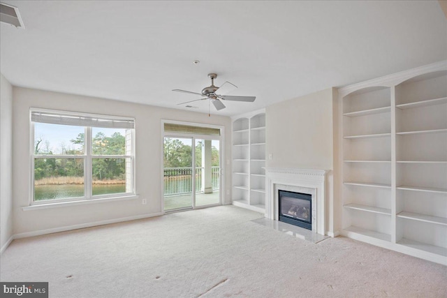 823 Oyster Bay Pl Unit 302, Solomons, MD 20688 - unfurnished living room with carpet flooring, built in shelves, ceiling fan, and a high end fireplace