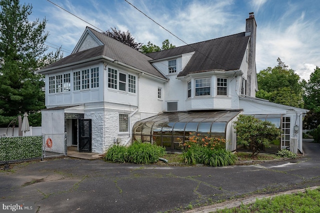 723 S Latches Ln, Merion Station, PA 19066 - view of front of house featuring stone siding, a chimney, a carport, stucco siding, and a shingled roof
