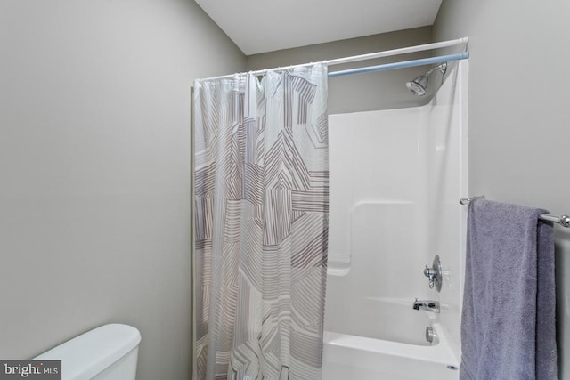 bathroom with shower / bath combination with curtain and toilet