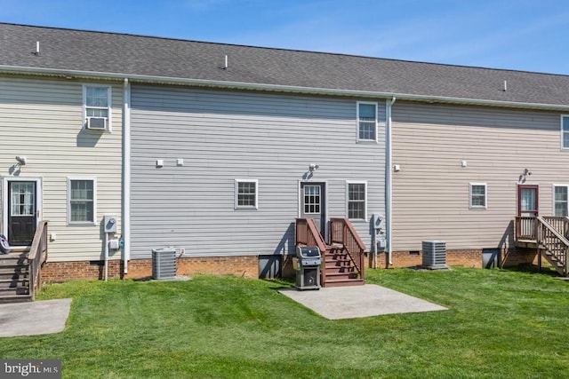 rear view of house with central AC unit, a yard, and crawl space