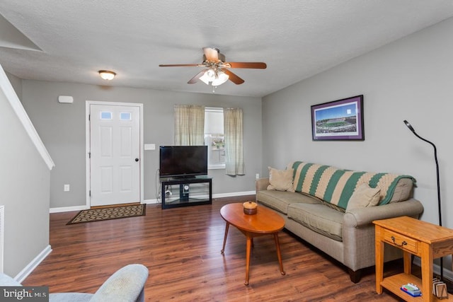 living area with wood finished floors, ceiling fan, and baseboards