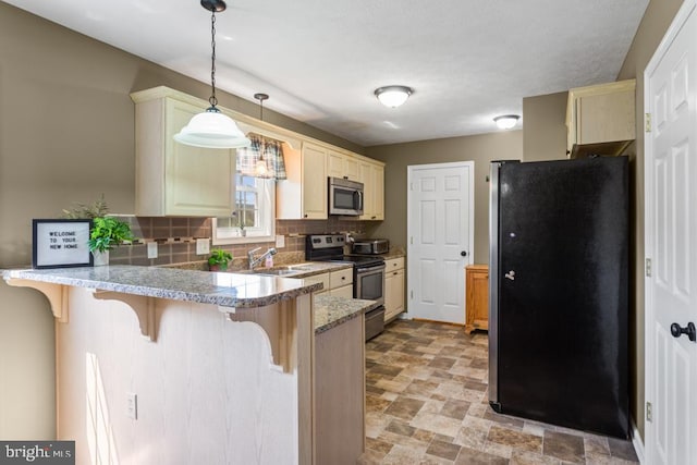 kitchen with tasteful backsplash, appliances with stainless steel finishes, a peninsula, a breakfast bar area, and stone finish flooring