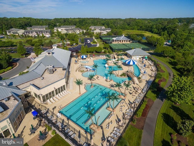aerial view of a pool area and a heavily wooded area