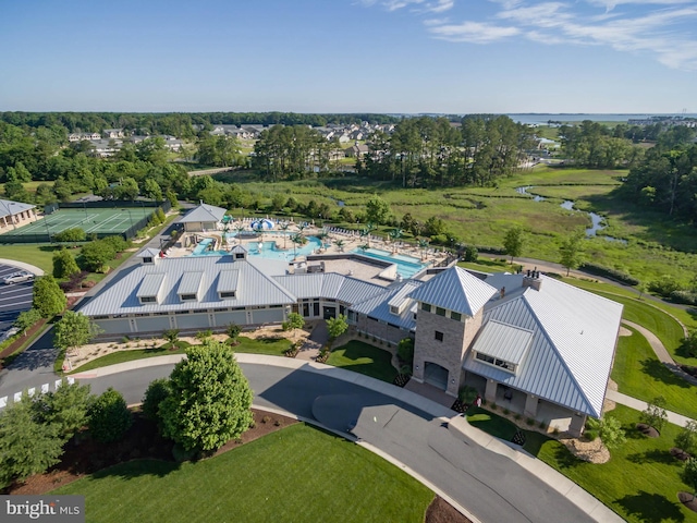 drone / aerial view of a pool and a nearby body of water