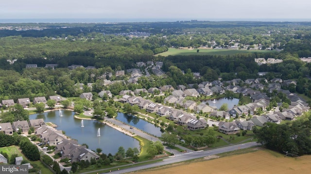 aerial view of property and surrounding area featuring nearby suburban area and a large body of water