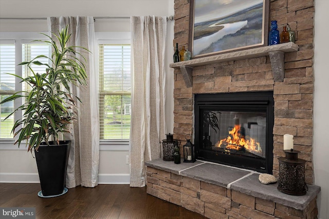 detailed view of baseboards, a fireplace, and wood finished floors
