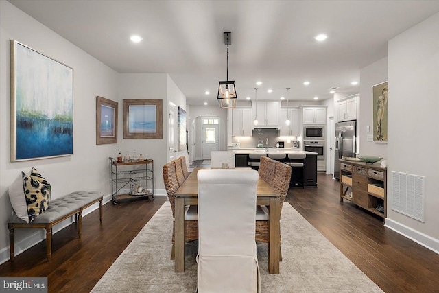 dining room with baseboards, dark wood-style flooring, and recessed lighting