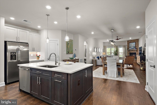 kitchen with appliances with stainless steel finishes, a sink, light countertops, white cabinetry, and recessed lighting