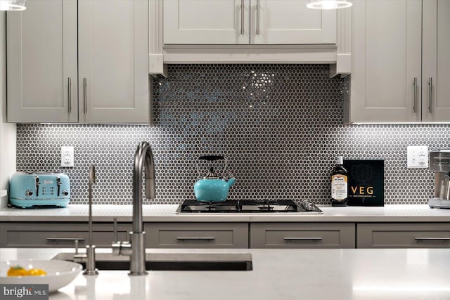 kitchen with gray cabinetry and tasteful backsplash