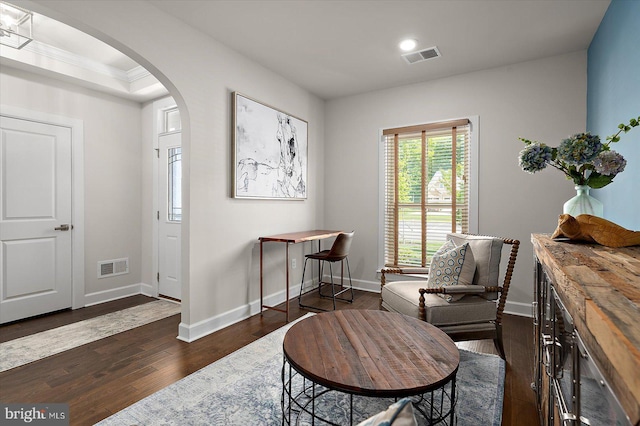 sitting room featuring arched walkways, dark wood-style flooring, recessed lighting, baseboards, and crown molding