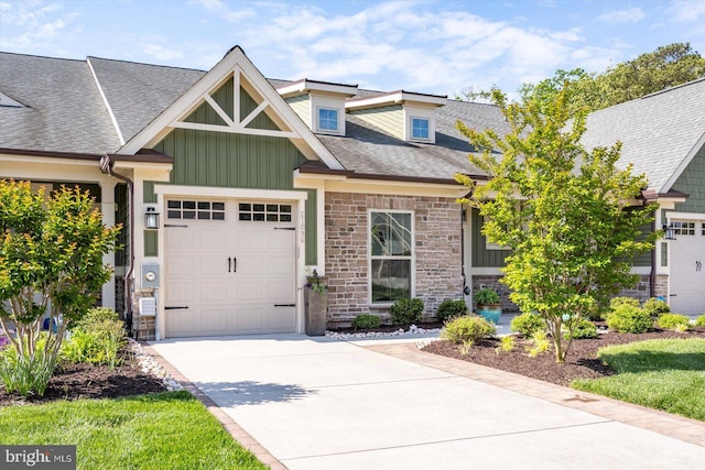 craftsman inspired home with driveway, roof with shingles, board and batten siding, a garage, and stone siding