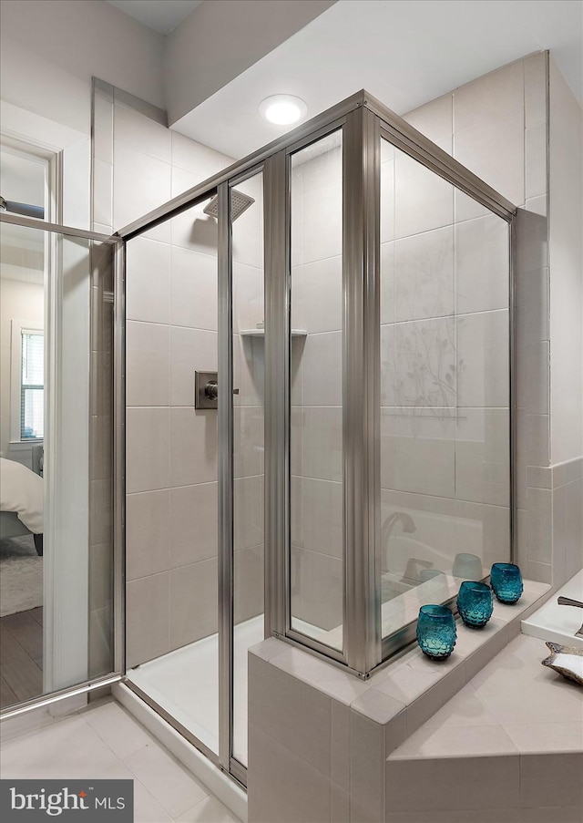 ensuite bathroom with a stall shower and tile patterned flooring