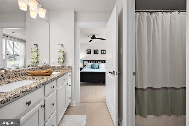 full bath featuring ensuite bathroom, double vanity, a ceiling fan, and tile patterned flooring