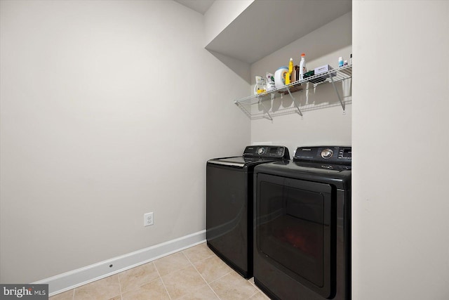 washroom with washing machine and dryer and baseboards