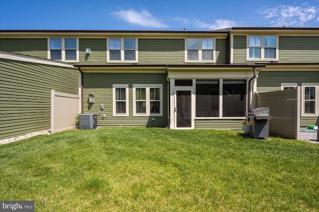 rear view of house featuring central air condition unit and a sunroom
