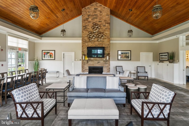 living area with wood ceiling, high vaulted ceiling, a wainscoted wall, a fireplace, and a decorative wall