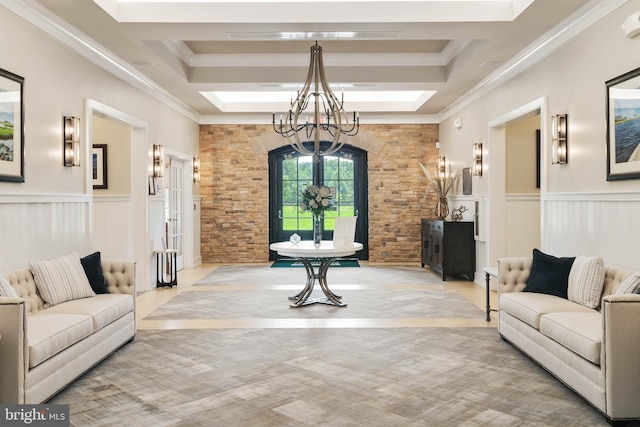 living area featuring a skylight, a chandelier, crown molding, a wainscoted wall, and a raised ceiling