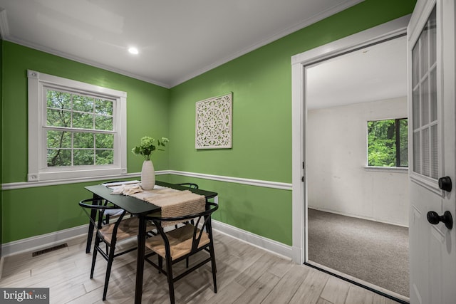 dining space with baseboards, crown molding, wood finished floors, and recessed lighting