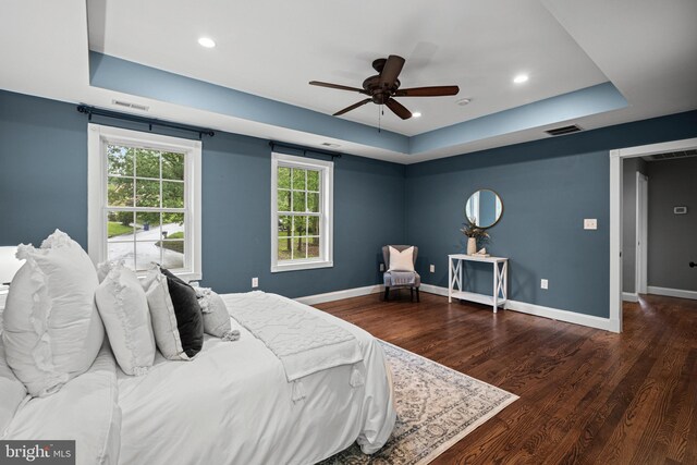 bedroom with a raised ceiling, wood finished floors, baseboards, recessed lighting, and a ceiling fan