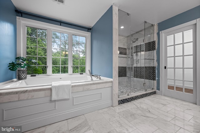 full bathroom featuring a stall shower, marble look tile flooring, and a garden tub