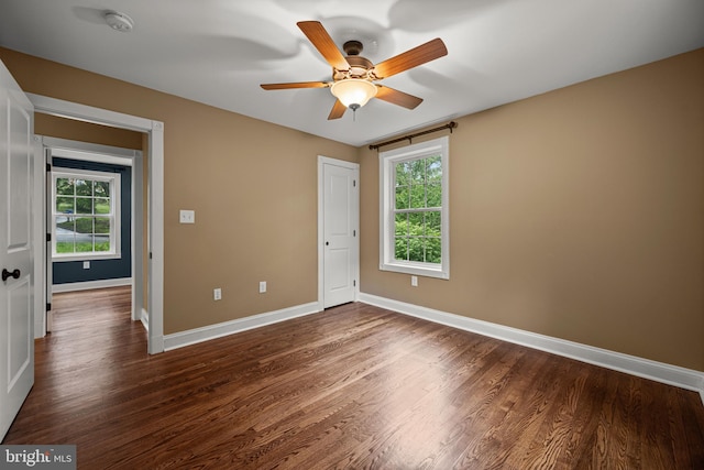 unfurnished bedroom featuring baseboards, dark wood-type flooring, and ceiling fan
