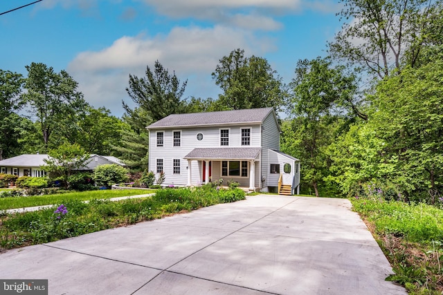 colonial-style house with driveway and a porch