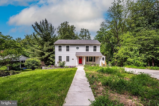 colonial-style house featuring a front lawn