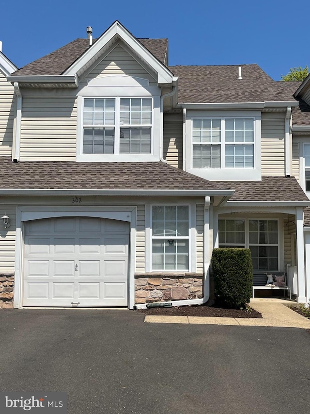302 Weston Ln Unit 23, New Hope, PA 18938 - townhome / multi-family property with stone siding, a garage, roof with shingles, and asphalt driveway