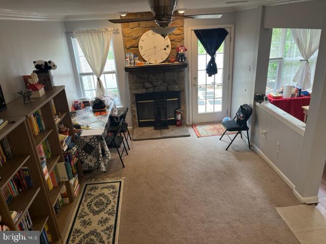 302 Weston Ln Unit 23, New Hope, PA 18938 - carpeted dining space with ornamental molding, ceiling fan, a stone fireplace, and baseboards