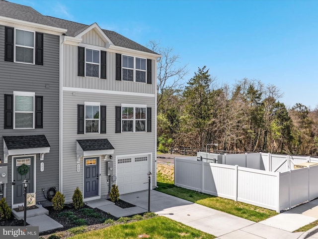 153 Kensington Cir, Middletown, VA 22645 - view of front facade with driveway, board and batten siding, fence, a garage, and roof with shingles