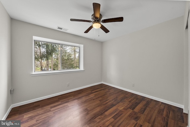 unfurnished room featuring baseboards, visible vents, and dark wood-style flooring
