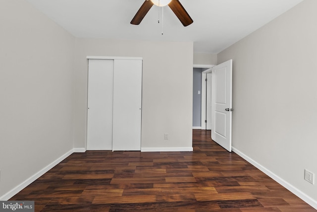 unfurnished bedroom featuring baseboards, wood finished floors, and a closet