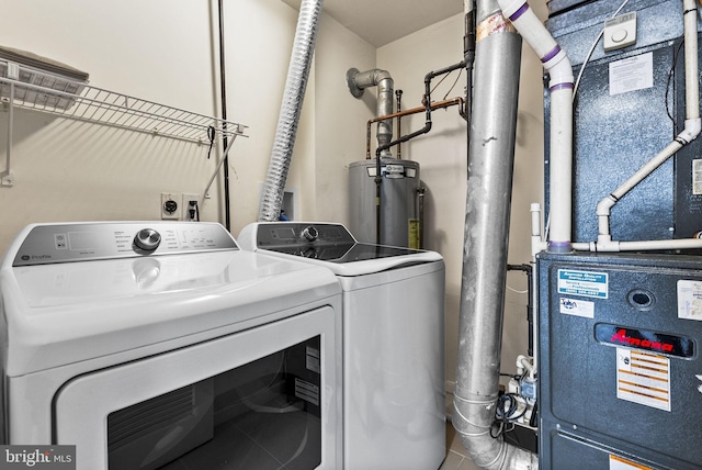laundry area with washing machine and clothes dryer, tile patterned floors, water heater, and laundry area