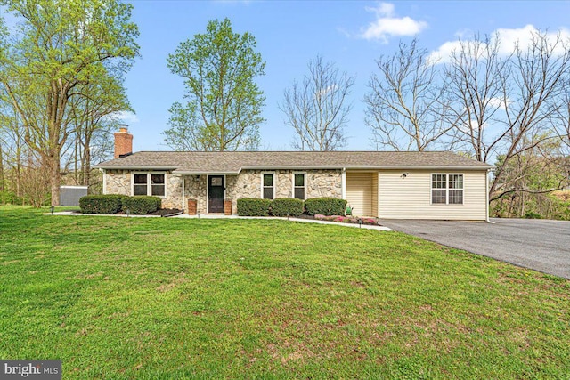 ranch-style home featuring aphalt driveway, a front yard, stone siding, and a chimney