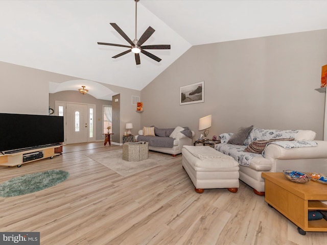 living area featuring lofted ceiling, wood finished floors, ceiling fan, and visible vents