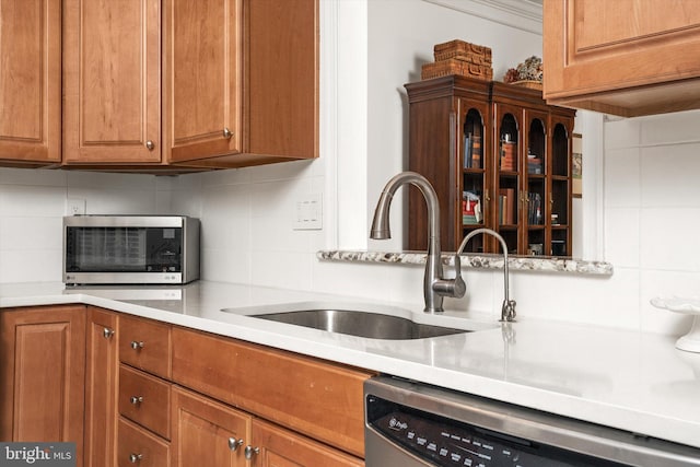 29 Sparrow Dr, Hamilton, NJ 08690 - kitchen with light countertops, backsplash, brown cabinets, stainless steel dishwasher, and a sink