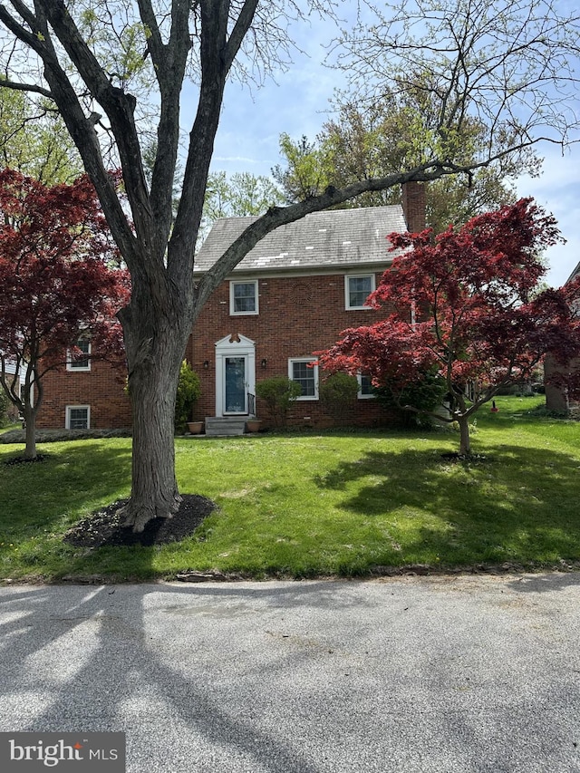 view of side of property featuring a lawn, a chimney, and entry steps